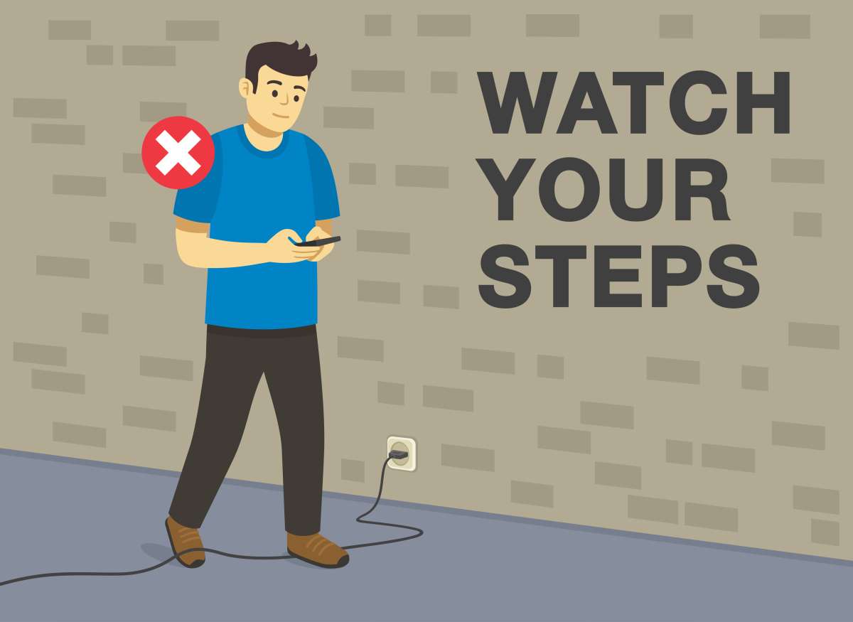 Man walking by cord with text - watch your steps